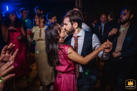 A couple sharing a romantic kiss while dancing on the dance floor at a wedding reception at Giardini del Meisino venue.
